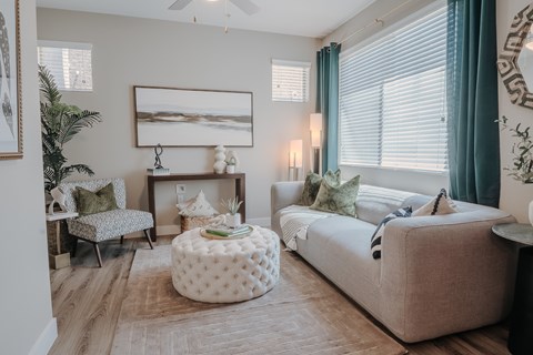 Cozy living room with couch, ottoman, arm chair and art.