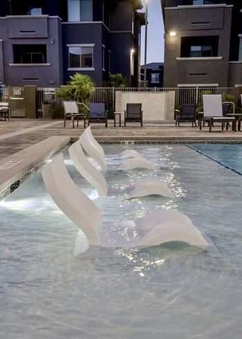 Shallow water sundeck with tanning chairs in swimming water at Level 25 at The Curve by Picerne, Nevada , 89148