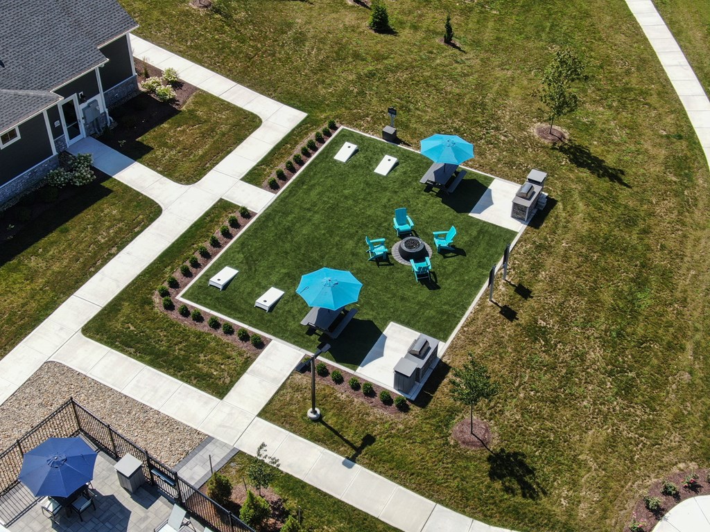 an aerial view of a yard with tables and umbrellas
