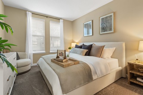 A bedroom with a large bed and a chair.