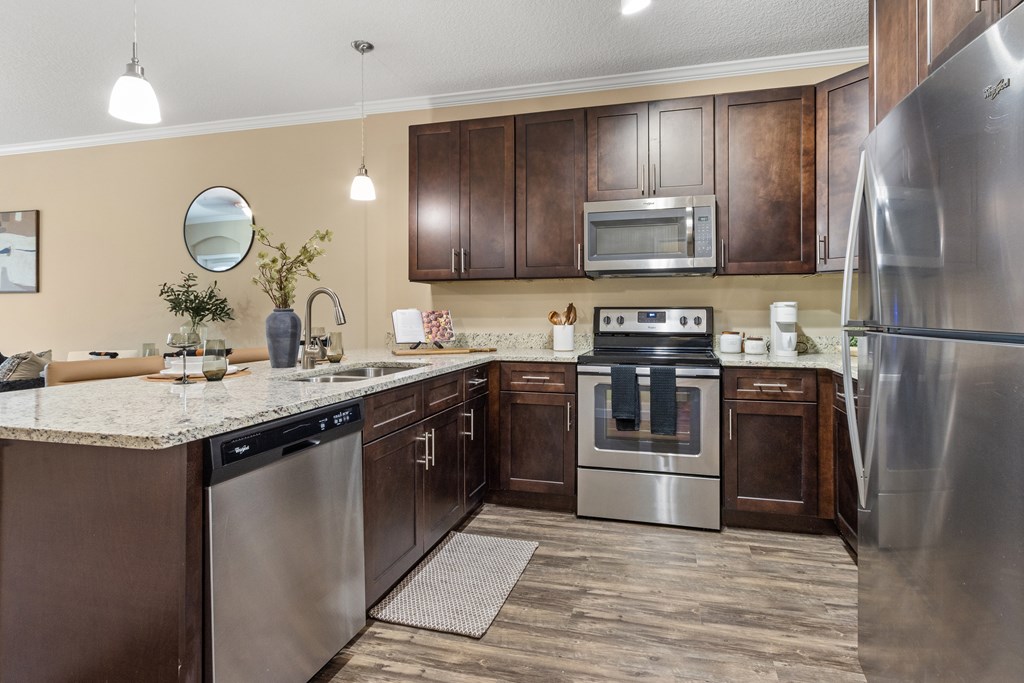A modern kitchen with stainless steel appliances and wooden cabinets.
