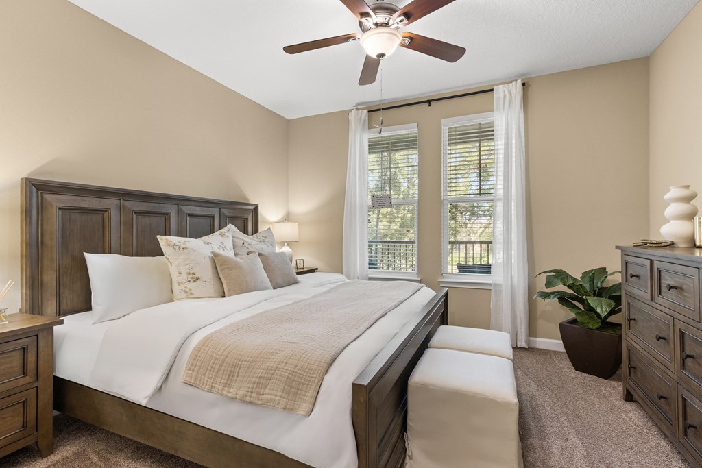A bedroom with a large bed and a ceiling fan.