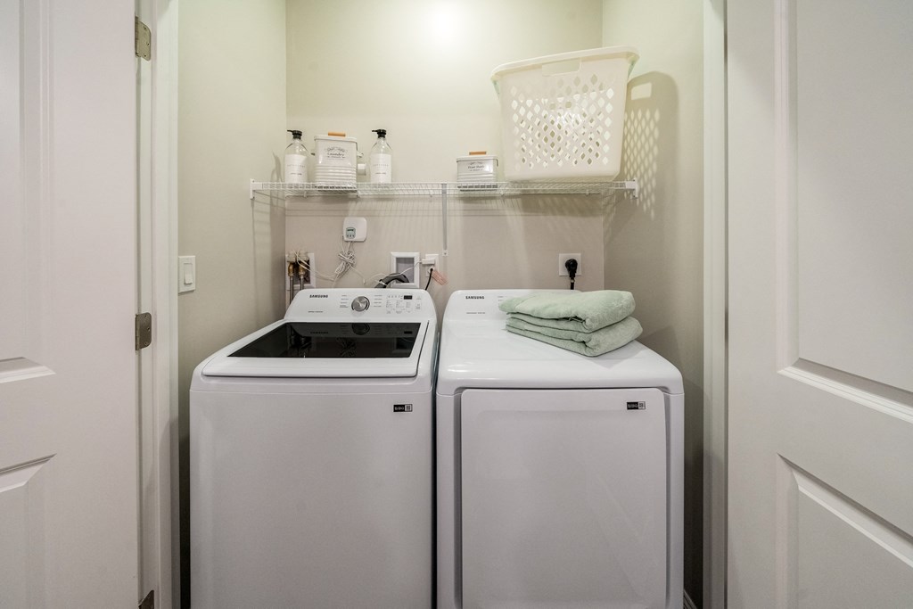 a white washer and dryer in a small laundry room