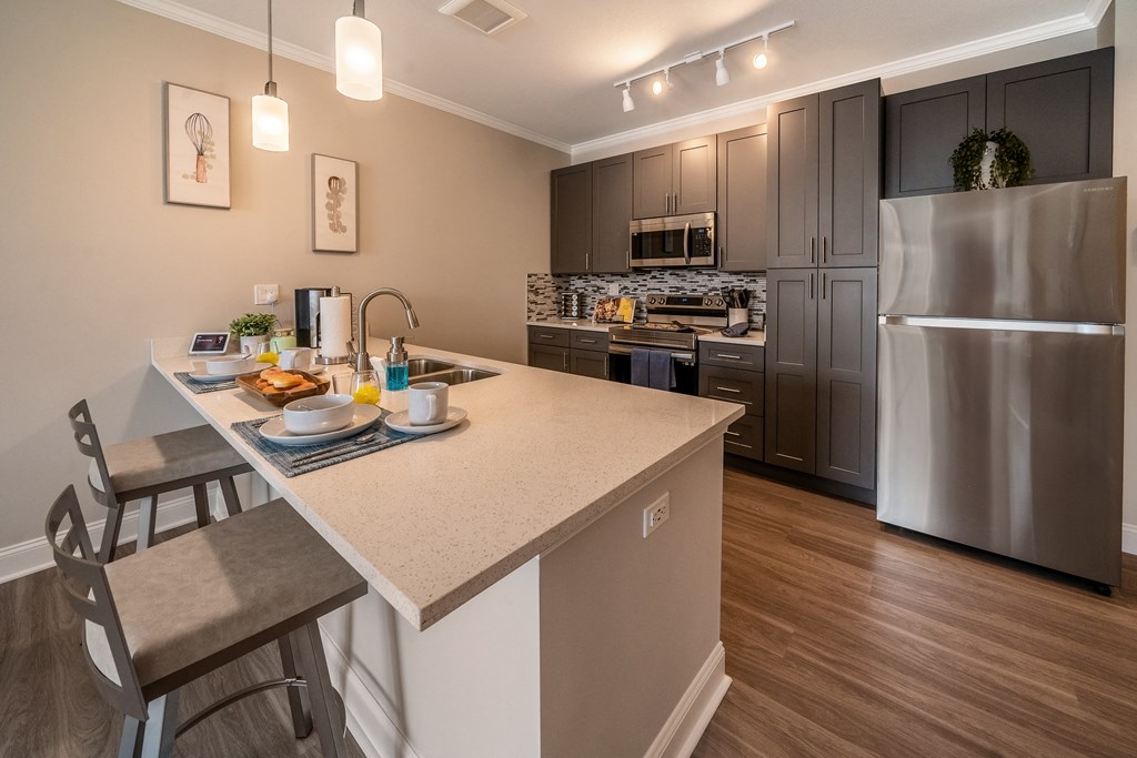 kitchen with island and stainless steel appliances at the preserve at great neck apartments