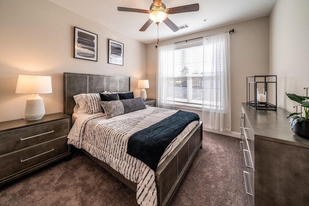 an empty bedroom with a bed and a ceiling fan