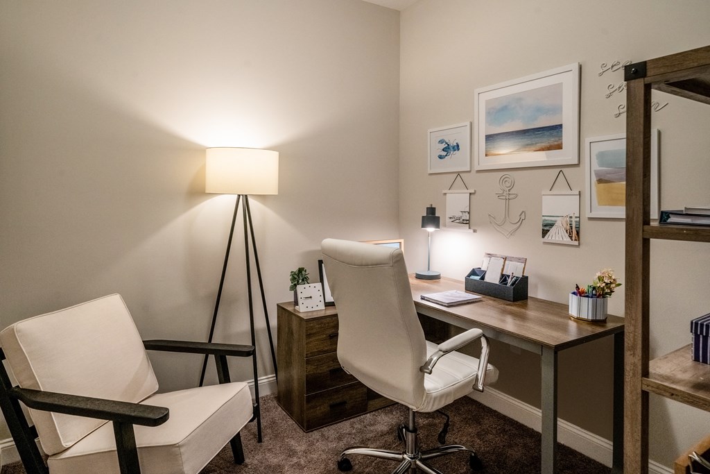 a home office with a desk and chair and a lamp