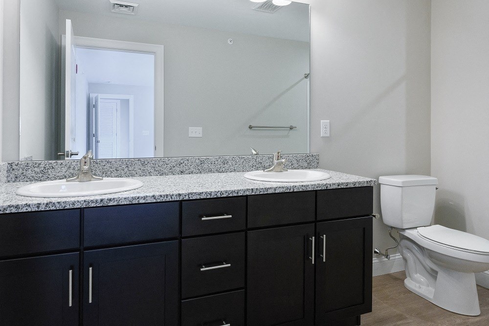an empty bathroom with two sinks and a toilet