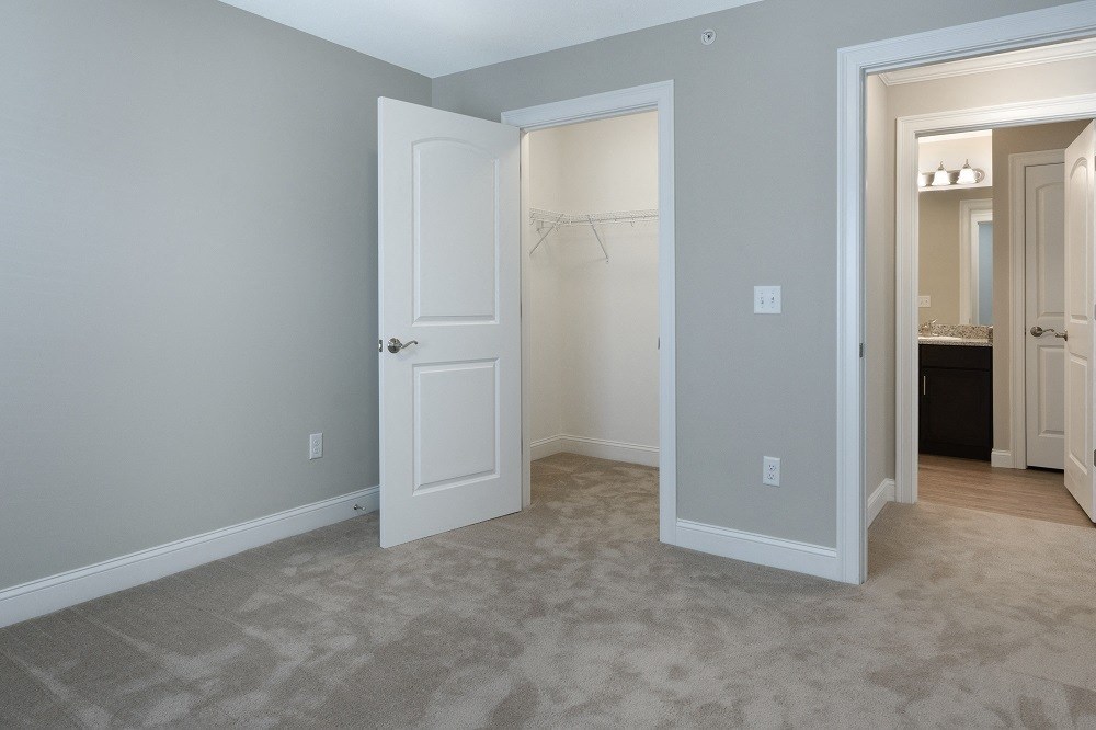 a bedroom with a closet and an open door to a bathroom