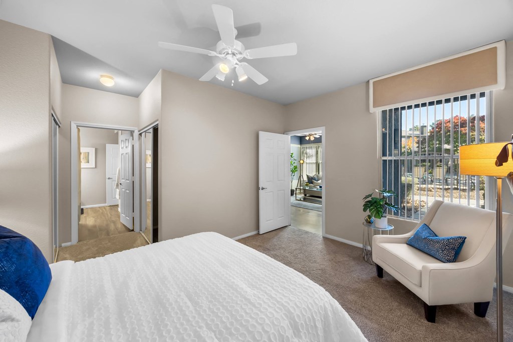 A bedroom with a large bed and a white ceiling fan. at The Equestrian by Picerne Apartments, Nevada, 89052