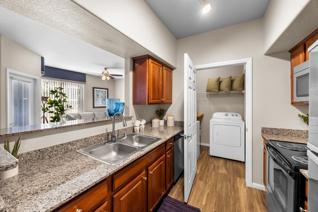 A kitchen with a sink, refrigerator, and oven. at The Equestrian by Picerne Apartments, Henderson, NV
