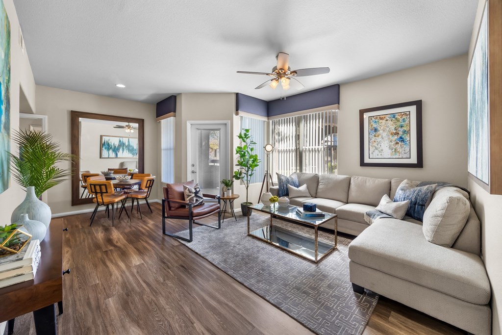 A living room with a white couch and a glass coffee table. at The Equestrian by Picerne Apartments, Henderson, NV, 89052