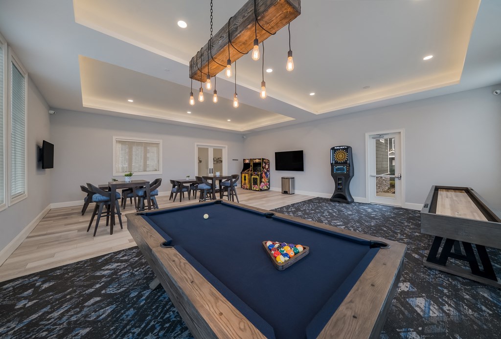 a game room with a blue pool table and a game system