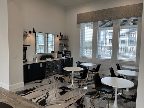 a kitchen and dining area with tables and chairs and windows