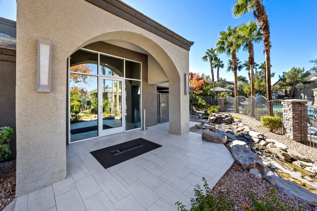 A modern house entrance with a stone wall and a black doormat. at The Equestrian by Picerne Apartments, Henderson, NV