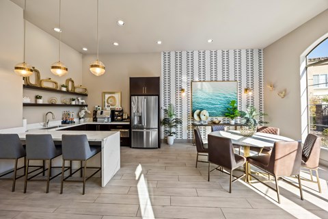 A modern kitchen with a dining table and chairs.