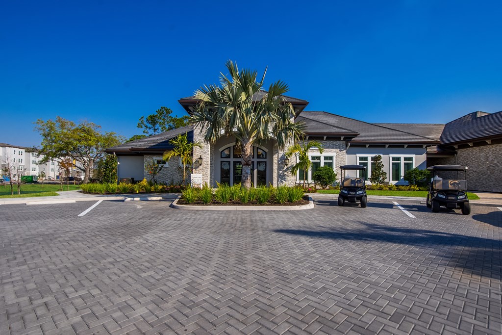 a large house with a driveway and palm trees in front of it  at The Oasis at Manatee River, Bradenton, FL, 34211