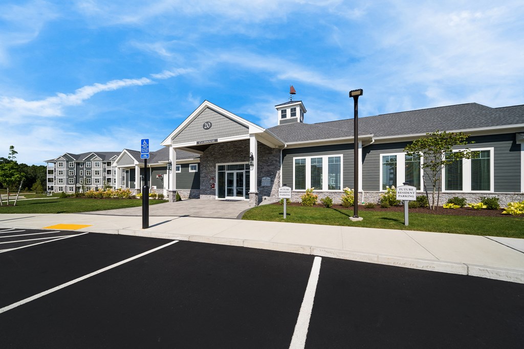 the front of a building with a parking lot and street signs