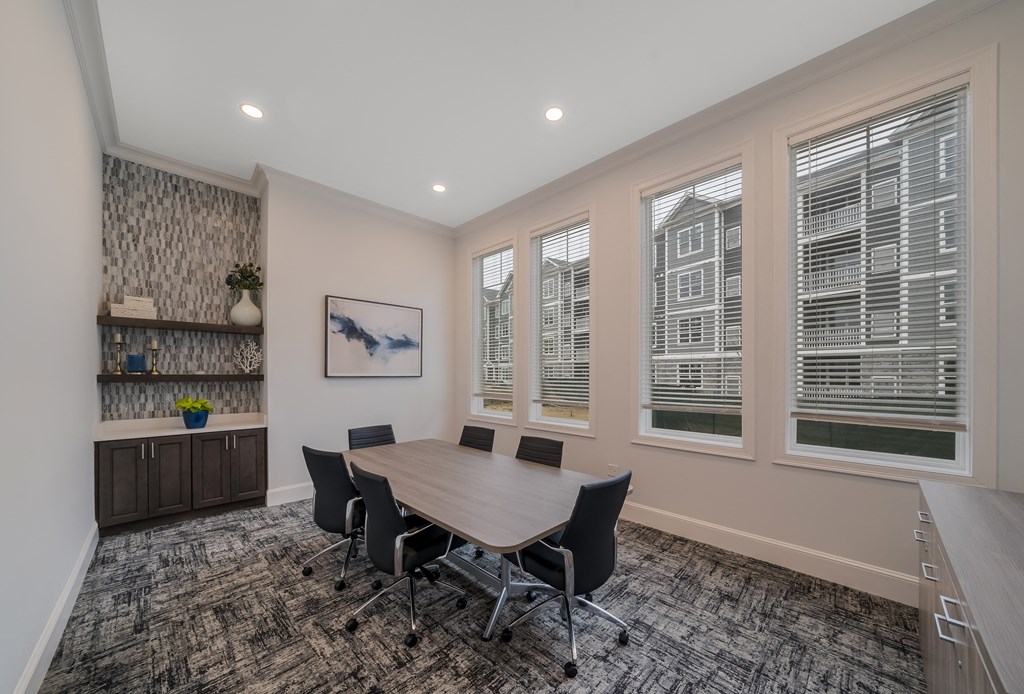 a conference room with a wooden table and chairs and windows