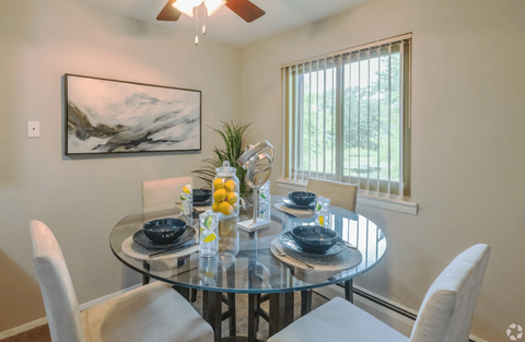 A dining room with a glass table and chairs.