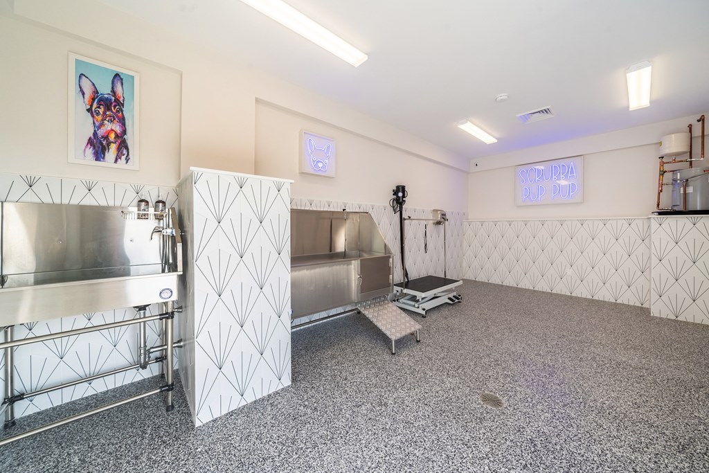 a room with a kitchen and a counter with a sink and a refrigerator