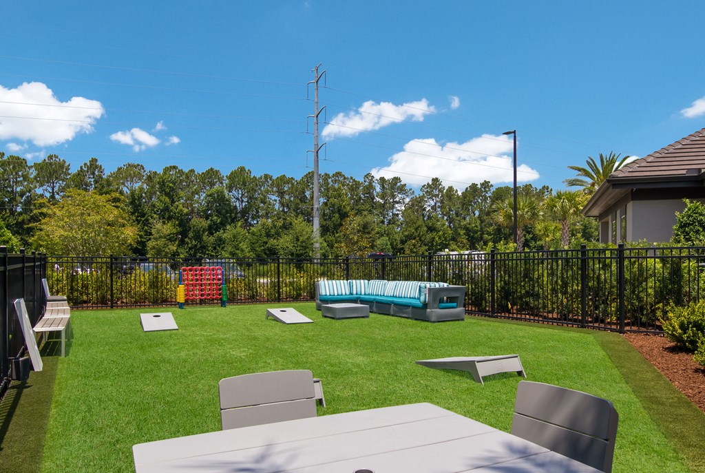 a backyard with a picnic table and chairs and a pool at The Oasis at Town Center, Jacksonville