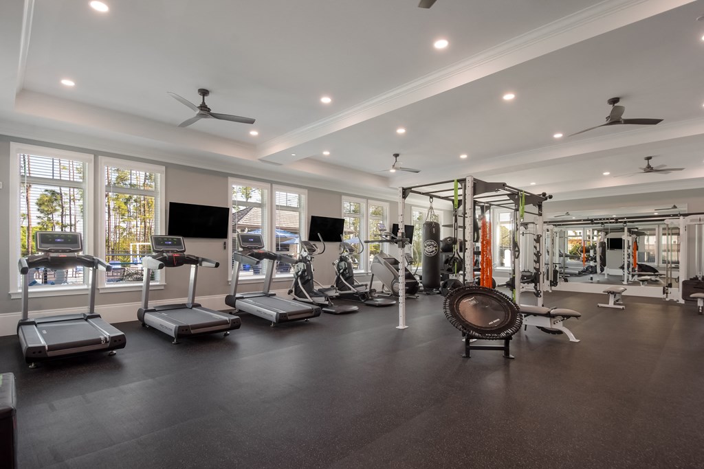 a large fitness room with cardio equipment and windows  at The Oasis at Manatee River, Bradenton