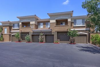 an empty driveway in front of a house with garage doors at The Fairways by Picerne Apartments, Nevada