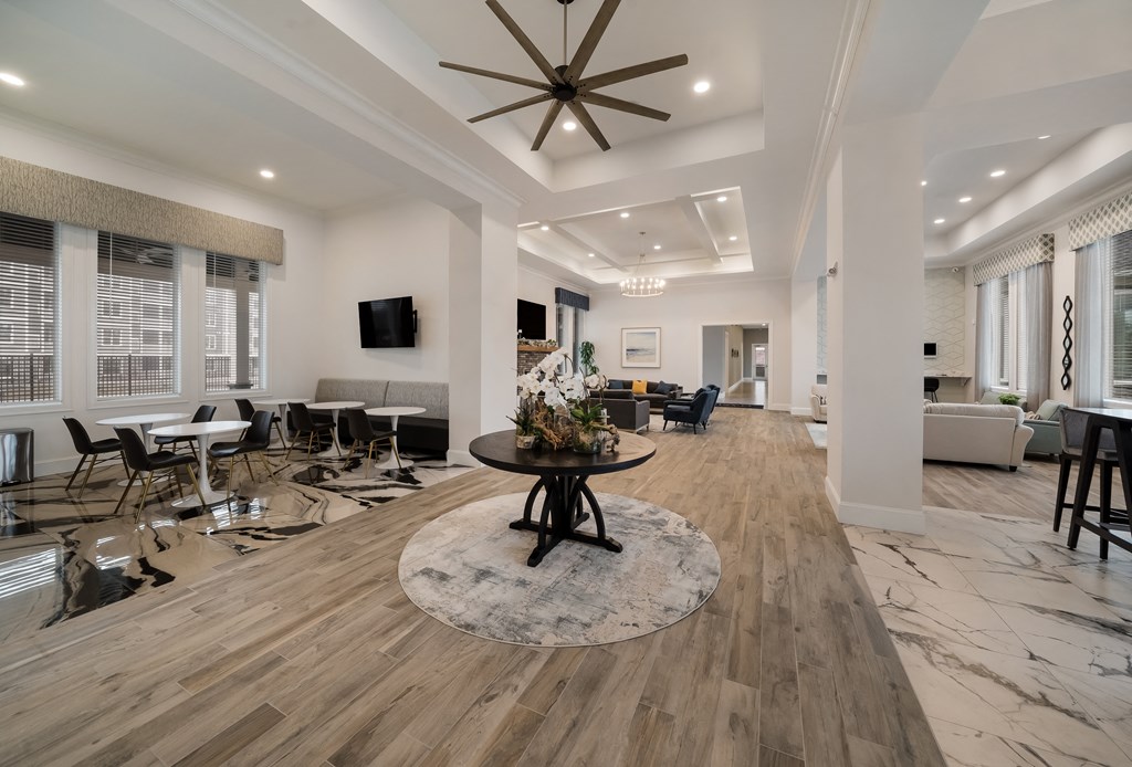 a large living room with a ceiling fan and a round table