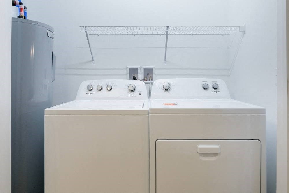 two washers and dryers in a room with a refrigerator