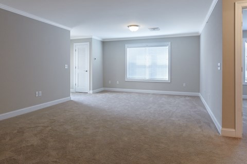 an empty living room with a window and a door