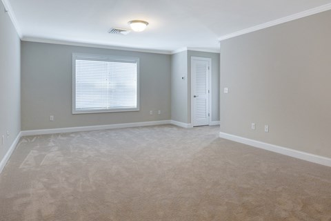 an empty living room with a window and a door