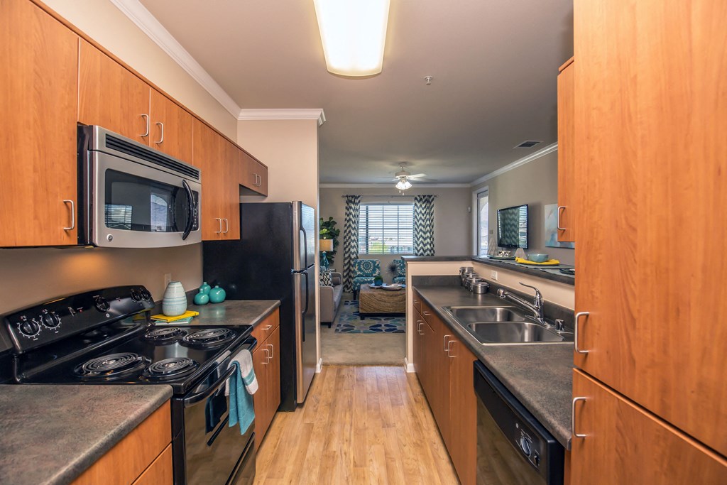 Galley style kitchen with stainless steel appliances and wood cabinets