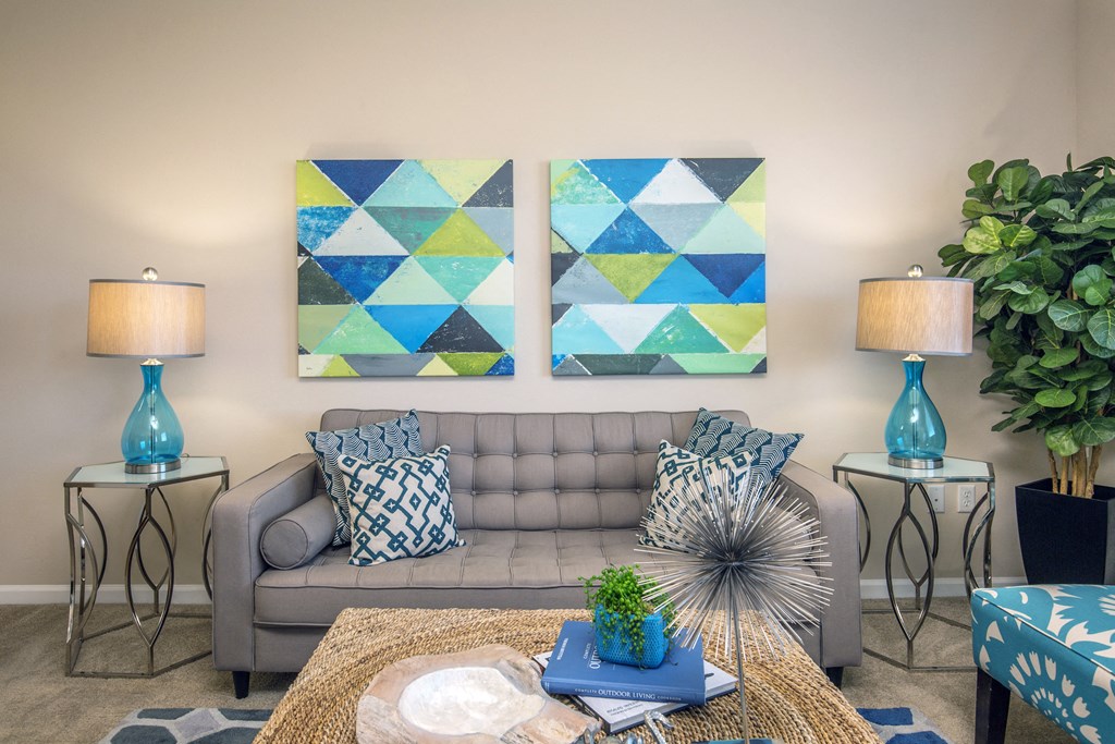 a living room with two paintings on the wall and a couch