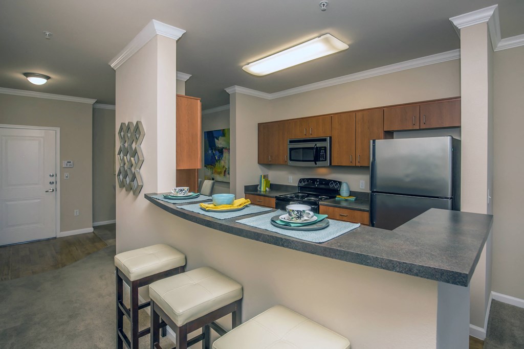 a kitchen with high counter top and a sink and a refrigerator