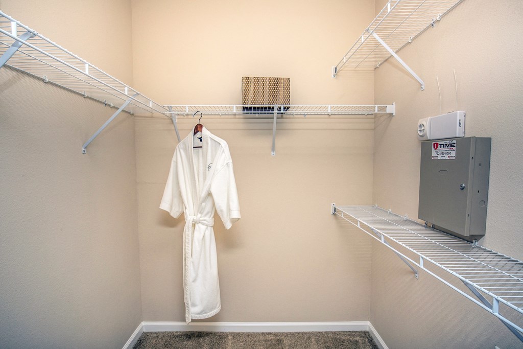 a spacious closet with a robe and a clothes rack