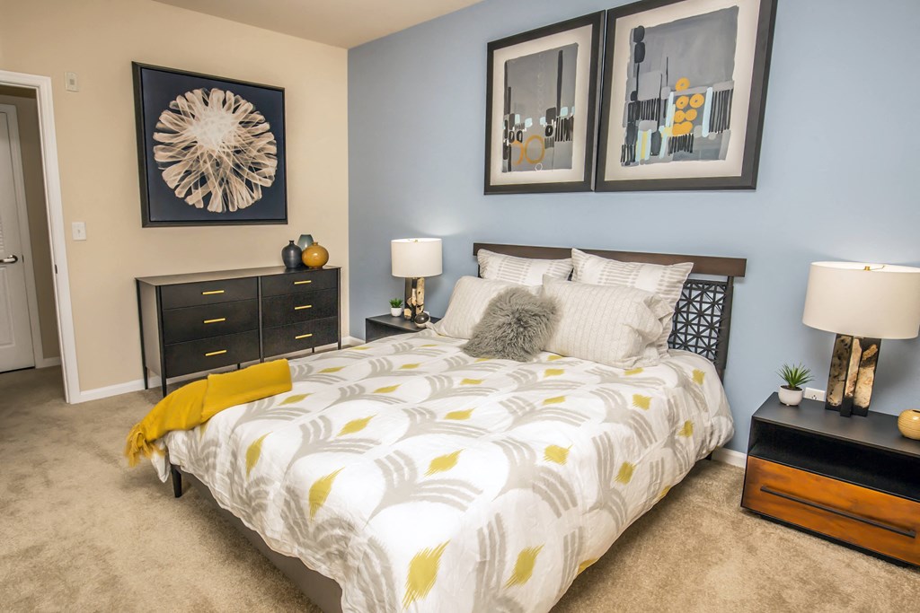 a bedroom with a bed and pictures on the wall