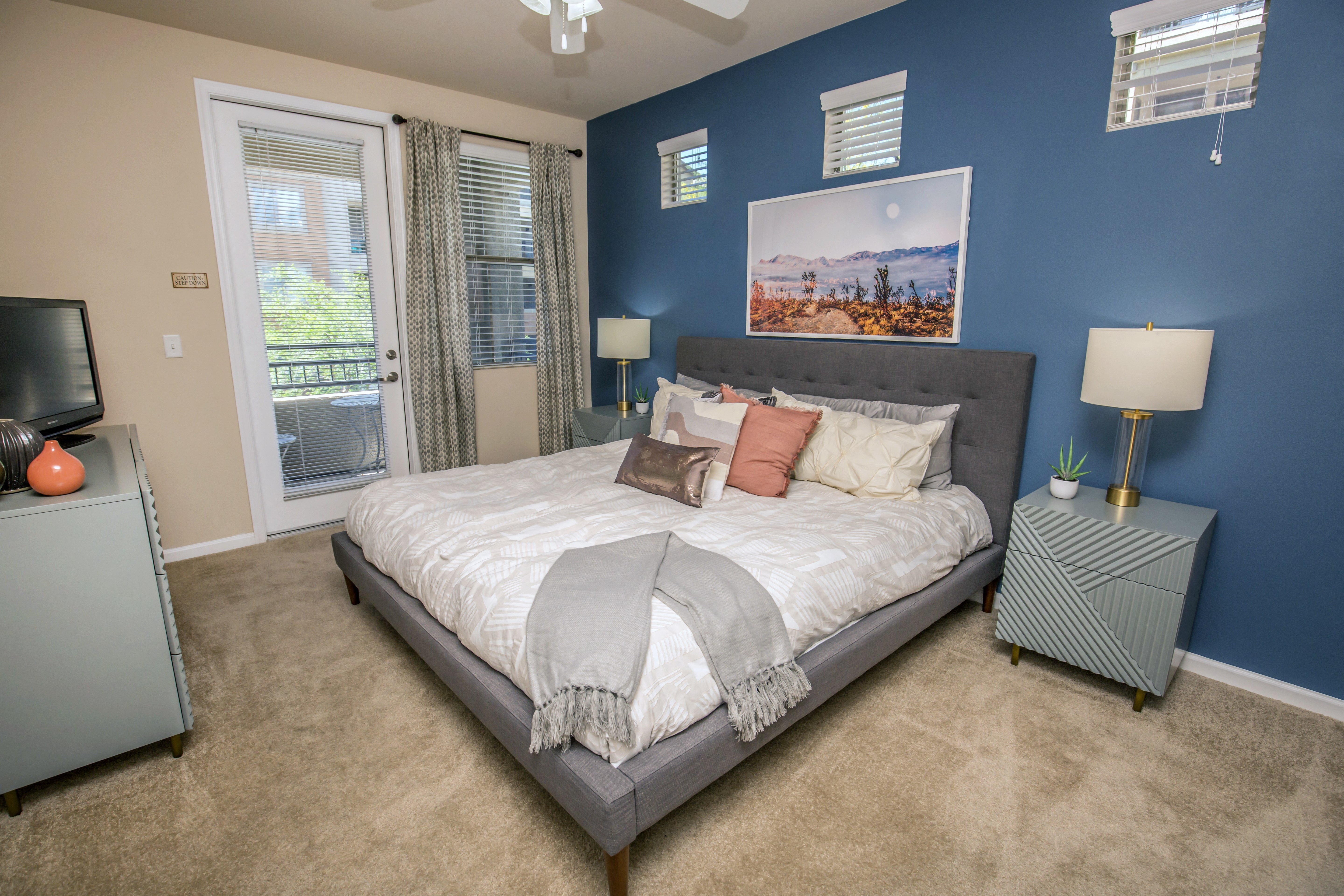a bedroom with blue walls and a bed with pillows