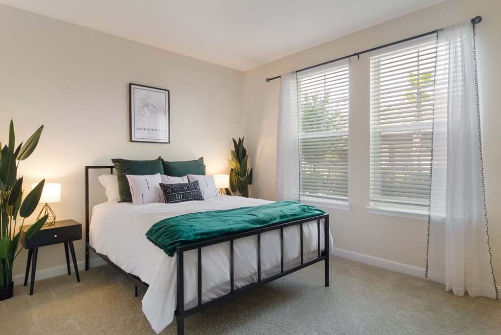 a bedroom with a bed and two windows at The Oasis at Town Center, Jacksonville, 32246