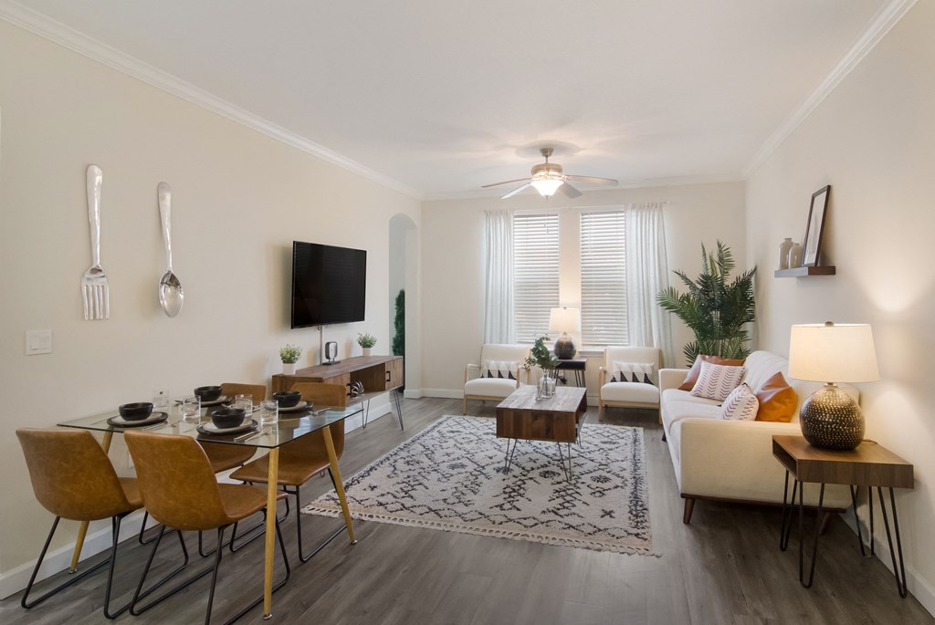 an open living room and dining room with a couch and a table at The Oasis at Town Center, Jacksonville, FL 32246