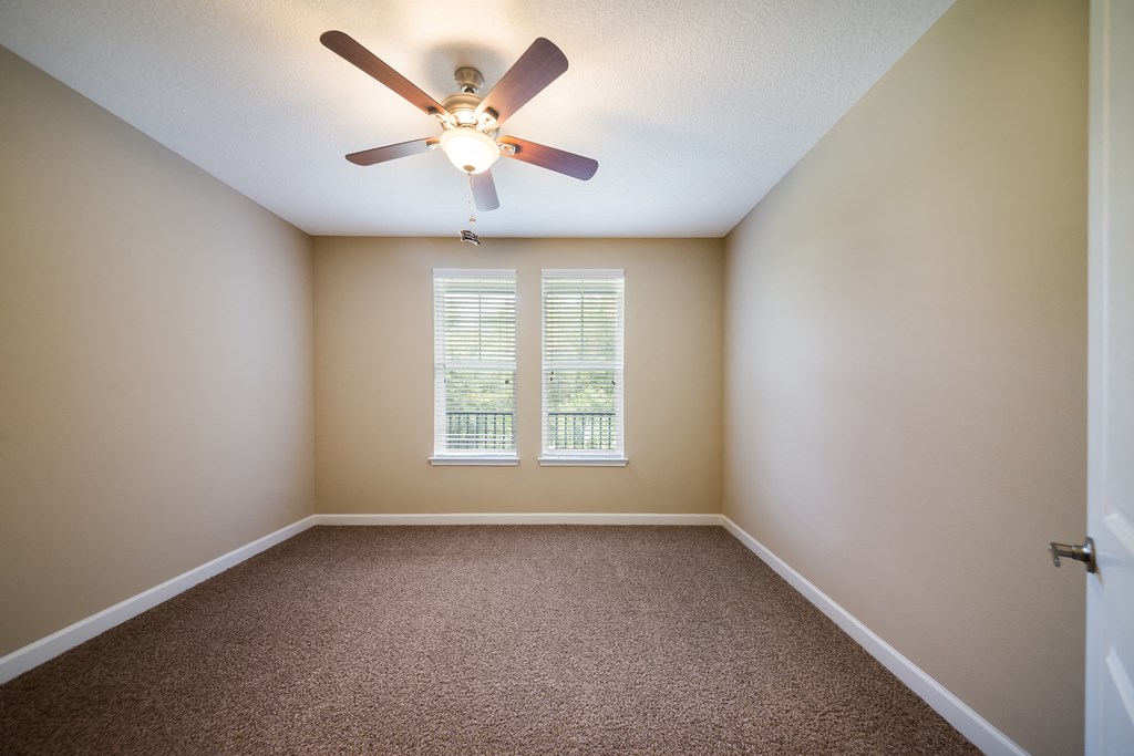 an empty room with a ceiling fan and a window at The Oasis at Highwoods Preserve, Tampa