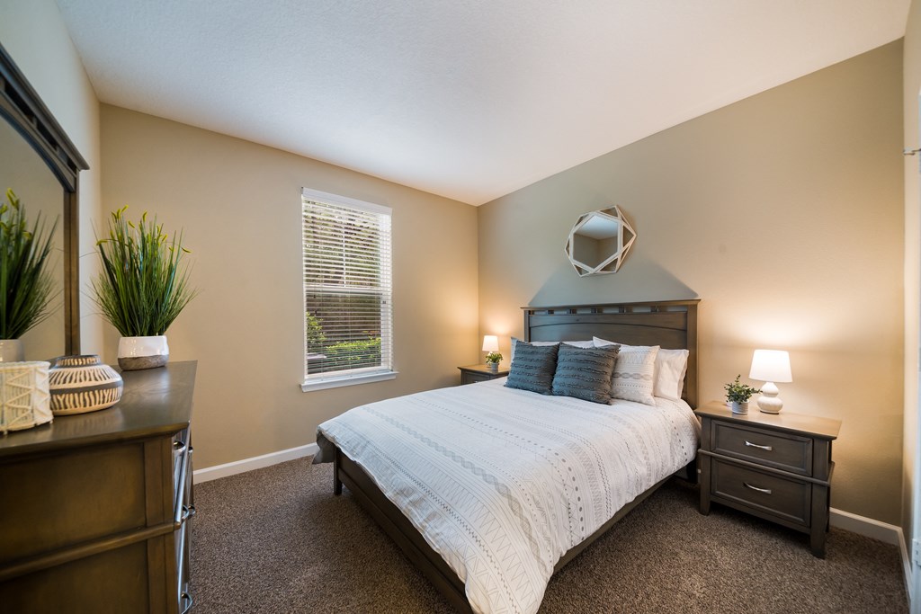 a bedroom with a bed and a dresser and a window a bedroom with a bed and a dresser and a window at The Oasis at Highwoods Preserve, Tampa, FL, 33647