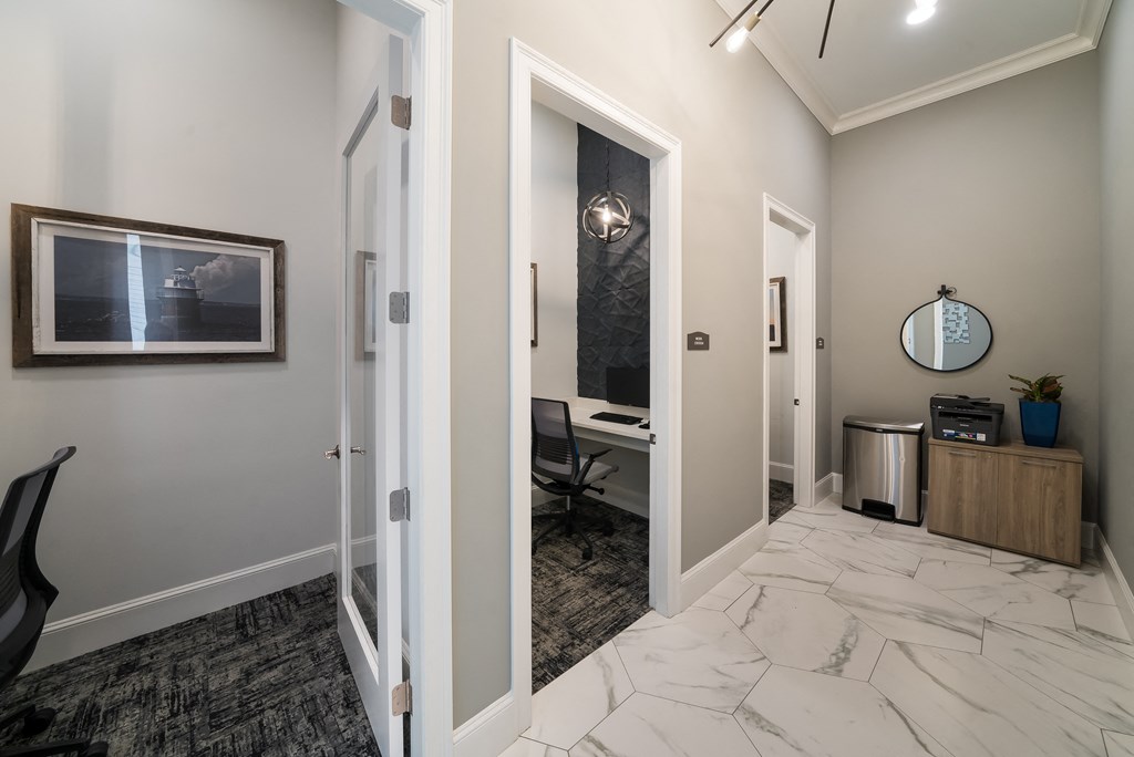a corridor with a desk and a mirror in a home office