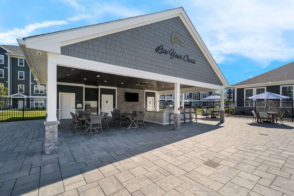 a covered patio with tables and chairs outside of a building