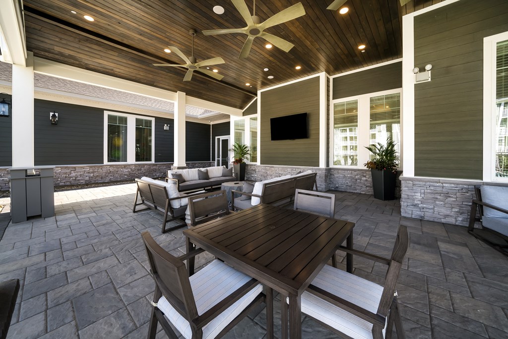 a covered patio with a table and chairs
