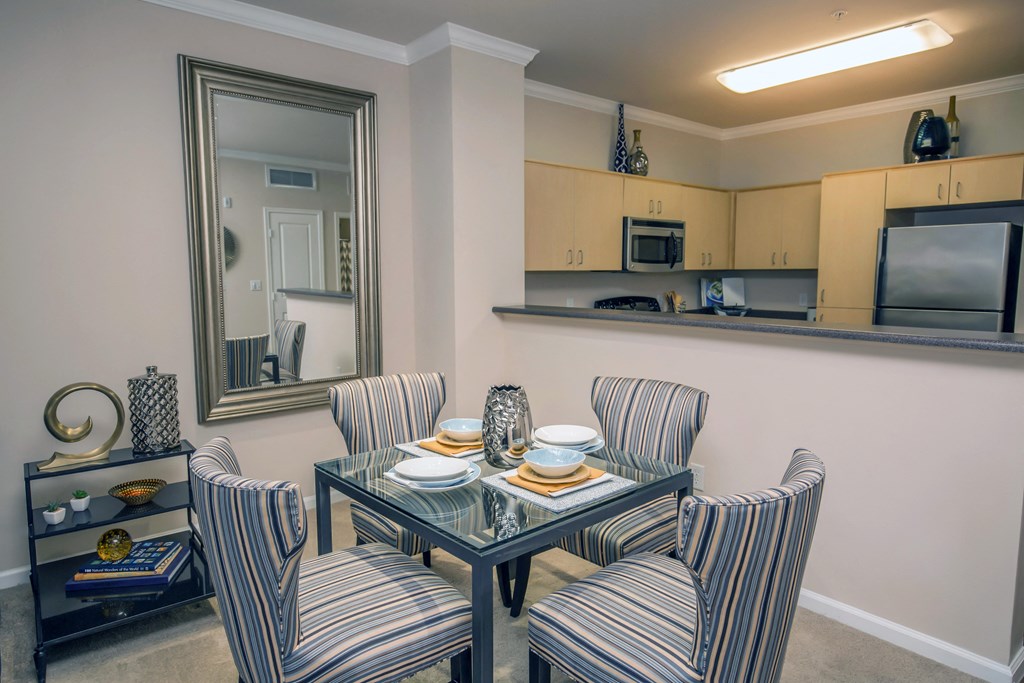 a dining room with a table and chairs and a kitchen
