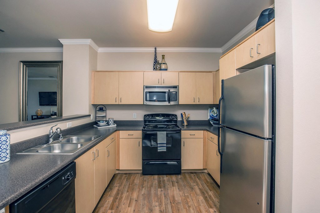 a kitchen with stainless steel appliances and wood flooring