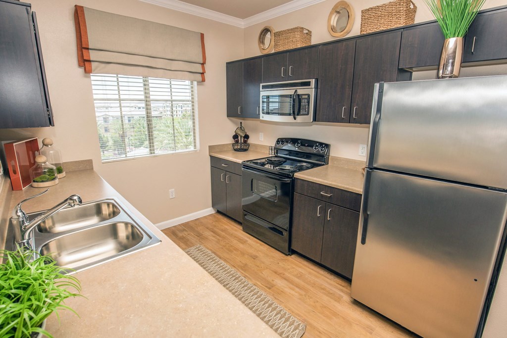 Kitchen with dark wood cabinet and a stainless refrigerator