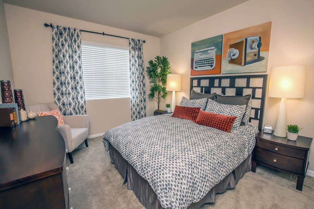 a bedroom with a bed and a desk and a window