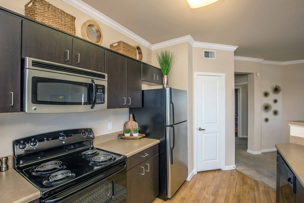 a kitchen with stainless steel appliances and a black refrigerator