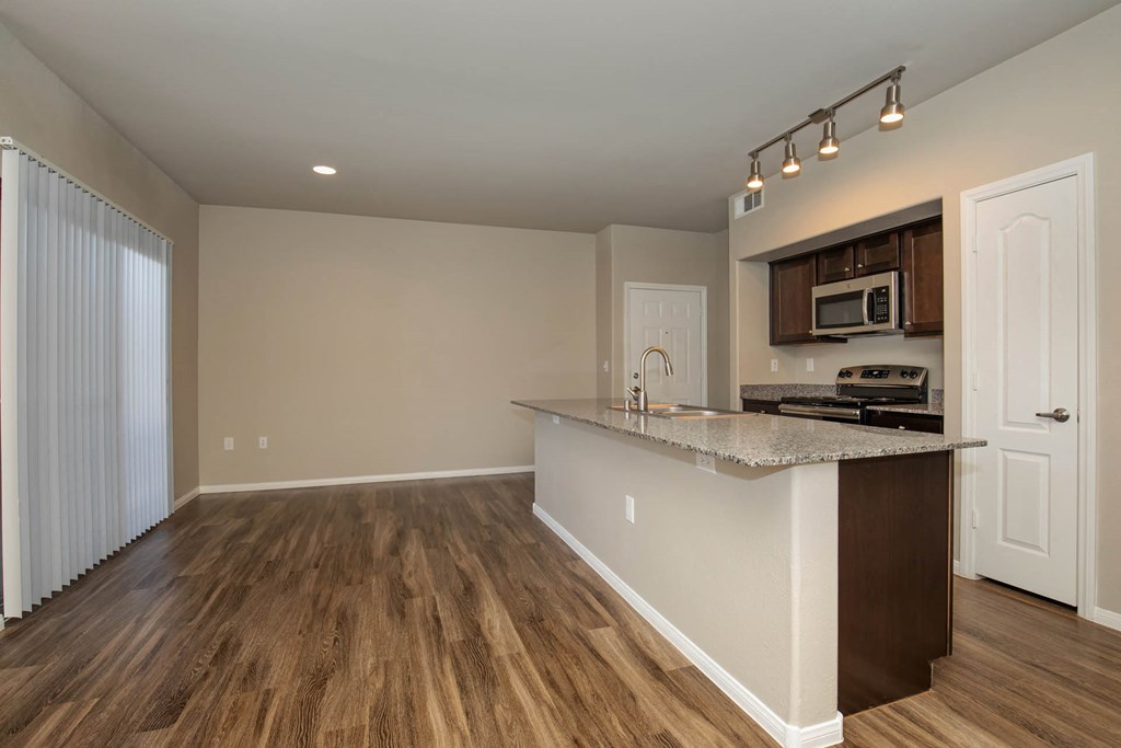 wooden cabinets and appliances in kitchen and dining areaat The Cantera by Picerne, Las Vegas, NV